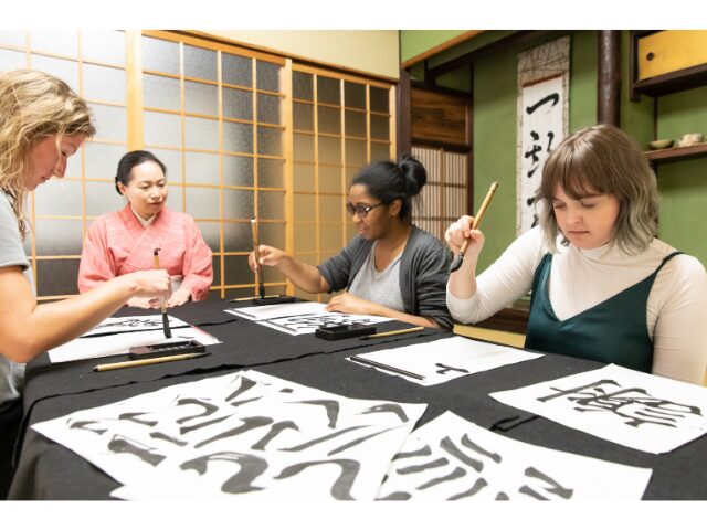 海外の女性たちが書道をしている