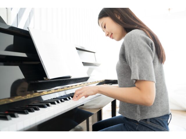 笑顔でピアノを弾く女性