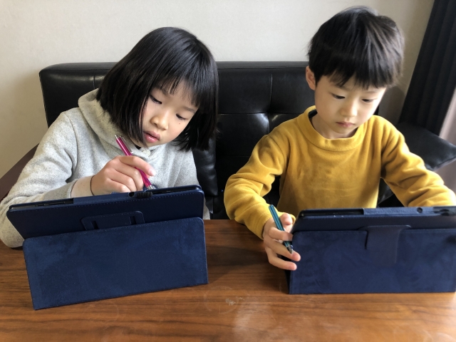 タッチペンでタブレットをさわる子ども