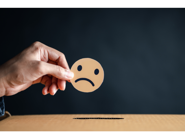 困り顔のイラストを持つ手